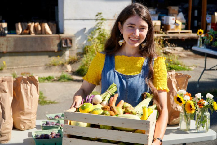 LifeCycles employee holding a box of fruit at Sharing Day